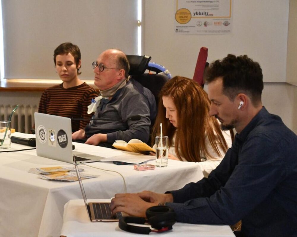 Julia Hofmarcher liest aus Huainiggs Buch vor. Julias Bruder, der Autor und seine Assistentin hören gespannt zu.